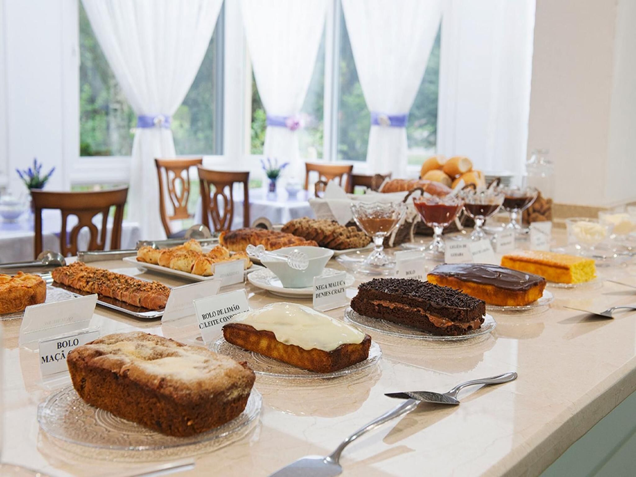 Una mesa de buffet con diversos productos horneados y postres.
