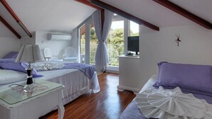 A bedroom with a bed, bedside table, and a TV on a stand. - Pousada Perfume de Canela (Canela)