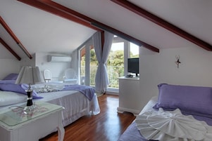 A bedroom with a bed, bedside table, and a TV on a stand.