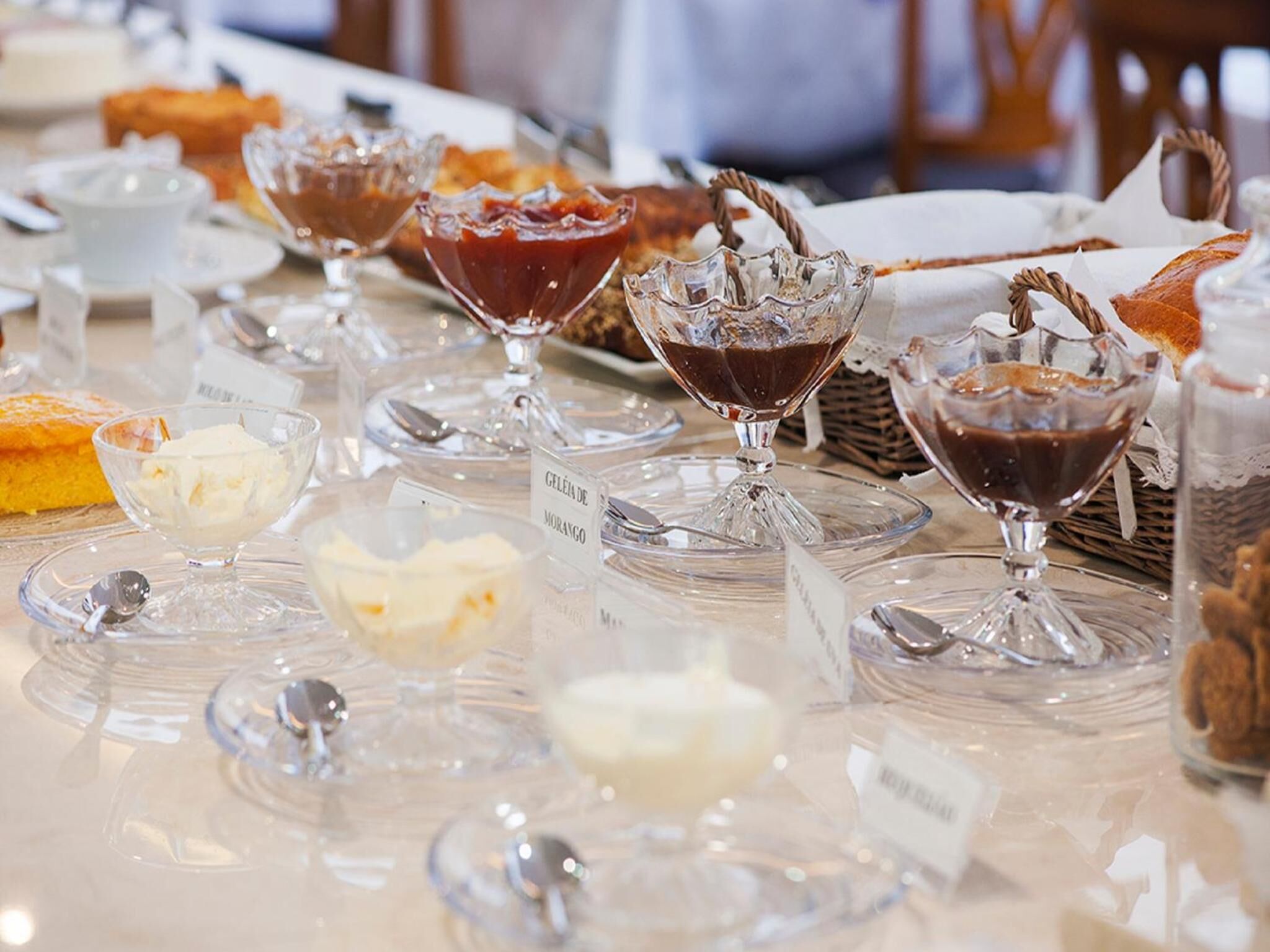 A dessert display with various ice cream flavors and a cake.