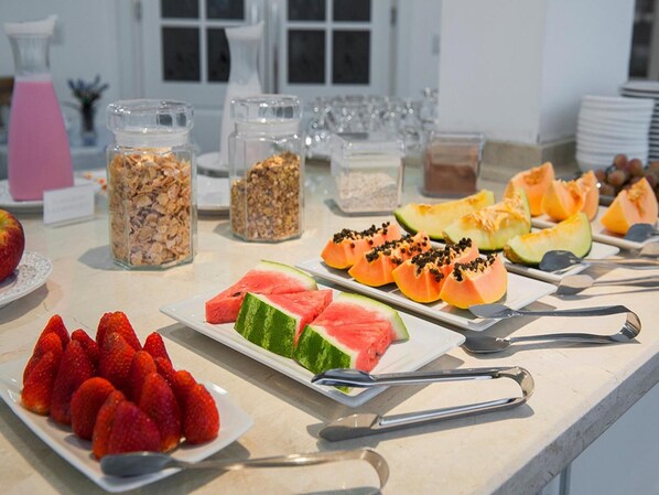 A buffet with various fruits and cereals.