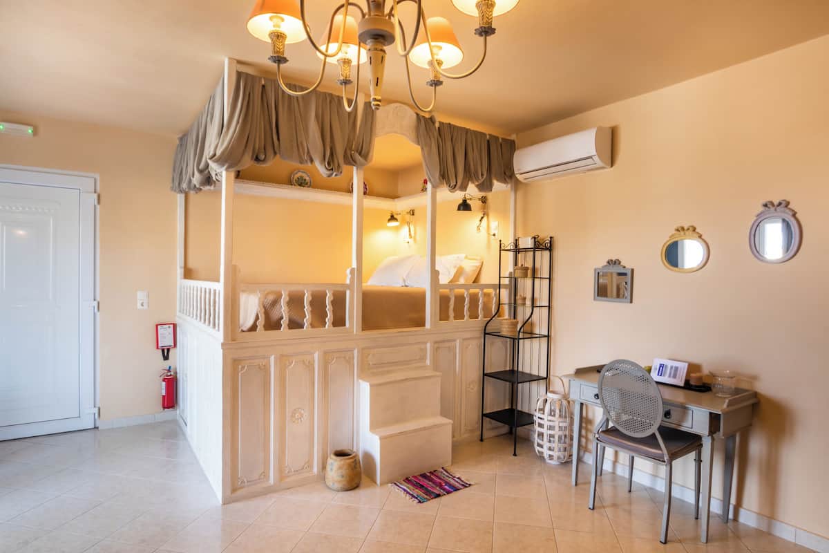 Ein Schlafzimmer mit einem Etagenbett, einem Schreibtisch mit Stuhl und einer Chandelier.