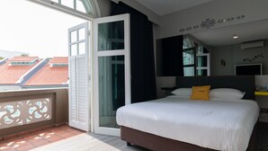 A modern hotel room with a large bed, a balcony, and a city view. - Butternut Tree Hotel (Singapore)