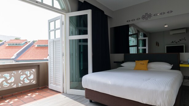 Una habitación de hotel moderna con una cama grande, un balcón y vistas a la ciudad.