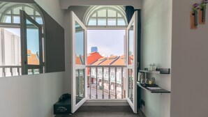 Un pasillo con un amplio ventanal de arco que da a un balcón con vistas a edificios.