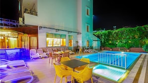A rooftop pool area with lounge chairs, a bar, and a dining table. - Alanya Beach Hotel (Alanya)