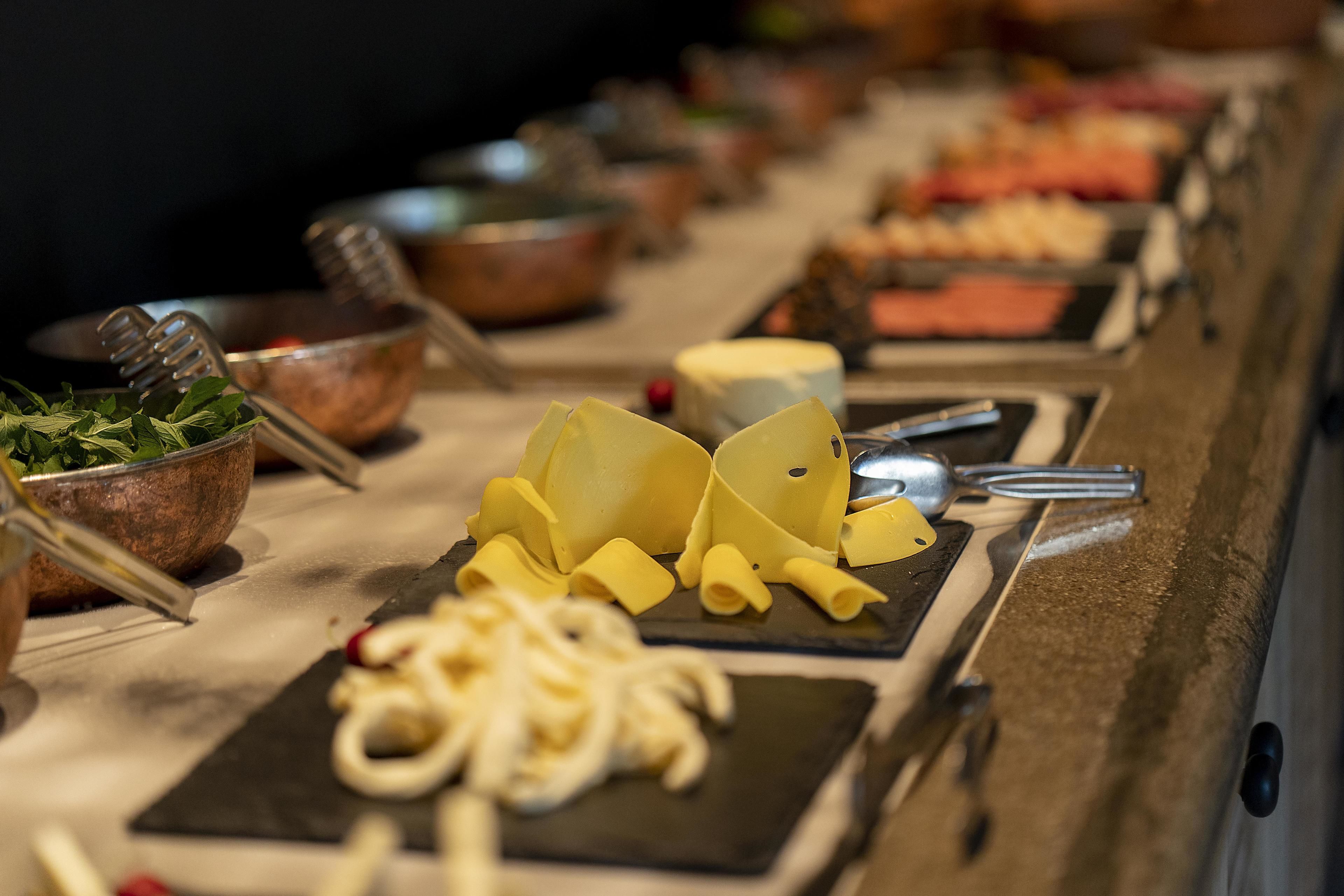 A buffet table with various food items and utensils.