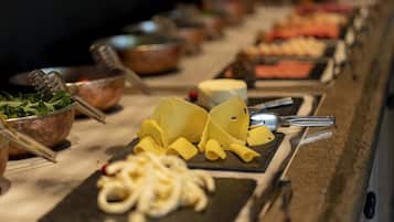 Una mesa de buffet con distintos alimentos y utensilios.