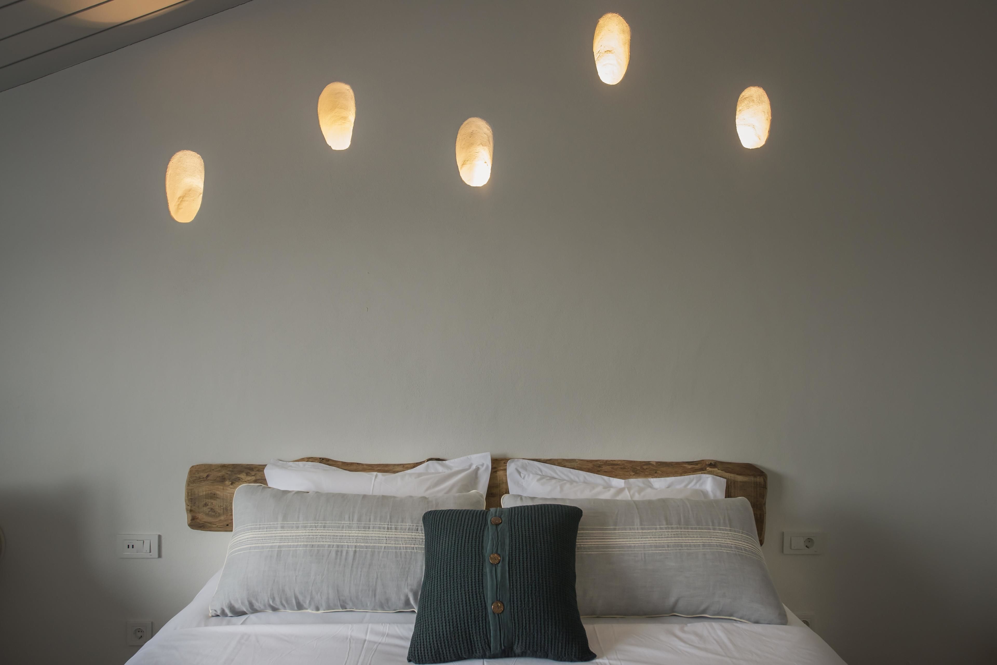 A bed with a wooden headboard, two pillows, and a knitted throw.