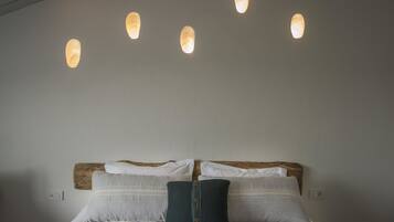A bed with a wooden headboard, two pillows, and a knitted throw.