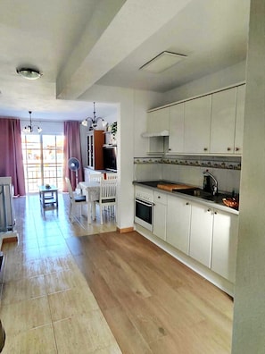 Una cocina amplia con armarios blancos y encimera de madera.
