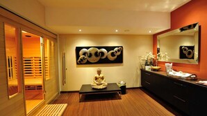 Ein modernes Badezimmer mit Holzboden, einem großen Spiegel, einer Buddha-Statue und einem Wandbild.