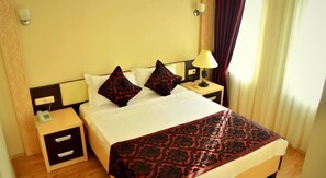 A hotel room with a bed, two bedside tables, a lamp, and a telephone. - Hotel Rumana (Anamur)