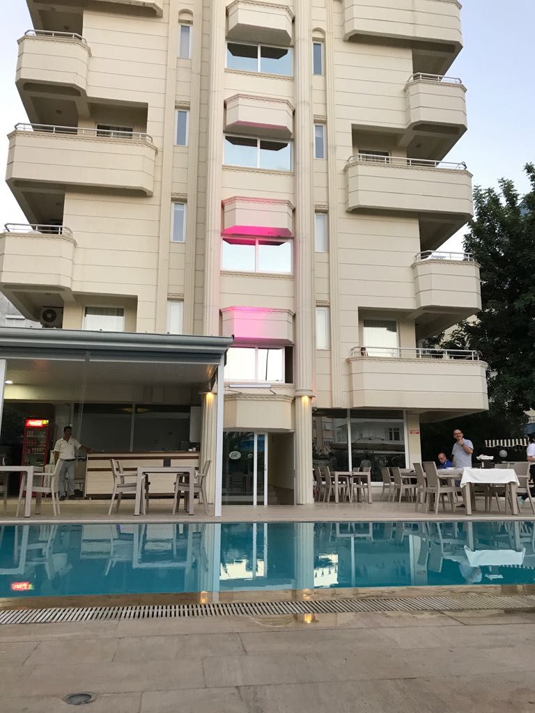 A multi-story building with a pool area in front.