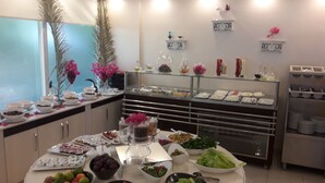 Un bufé con diversos alimentos y una pared decorativa con jarrones.