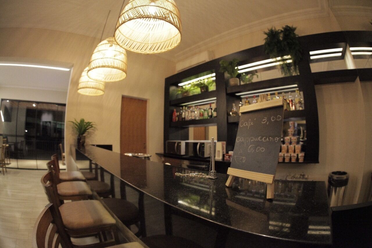 A modern bar area with a chalkboard menu, seating, and a well-lit interior.