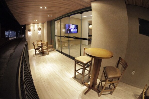A restaurant with wooden flooring, a round table, and two chairs.