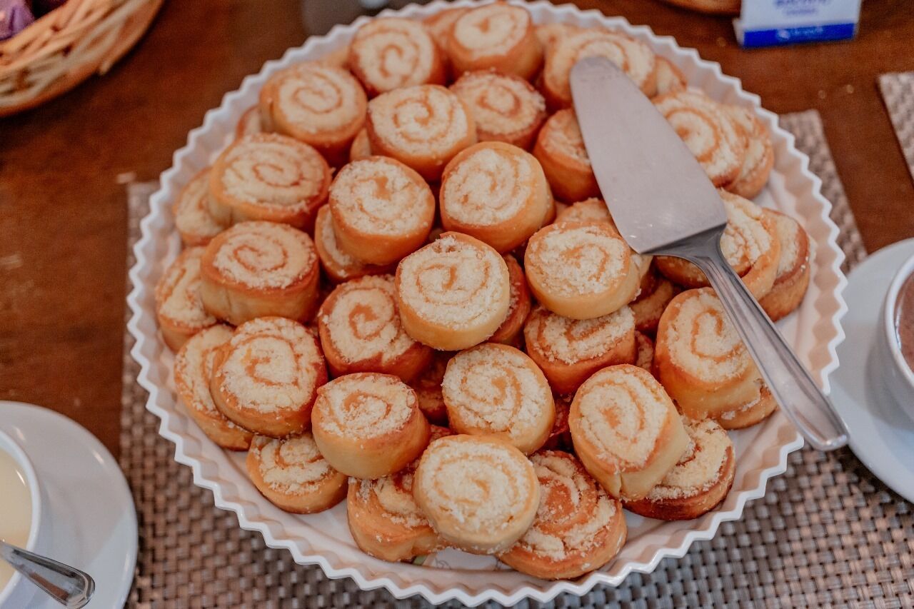 Een bord kaneelbroodjes met een opscheplepel.