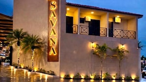 Hotel 'Savana' met een modern design, herkenbaar aan een opvallend verticaal bord, balkons en goed verlichte omgeving.