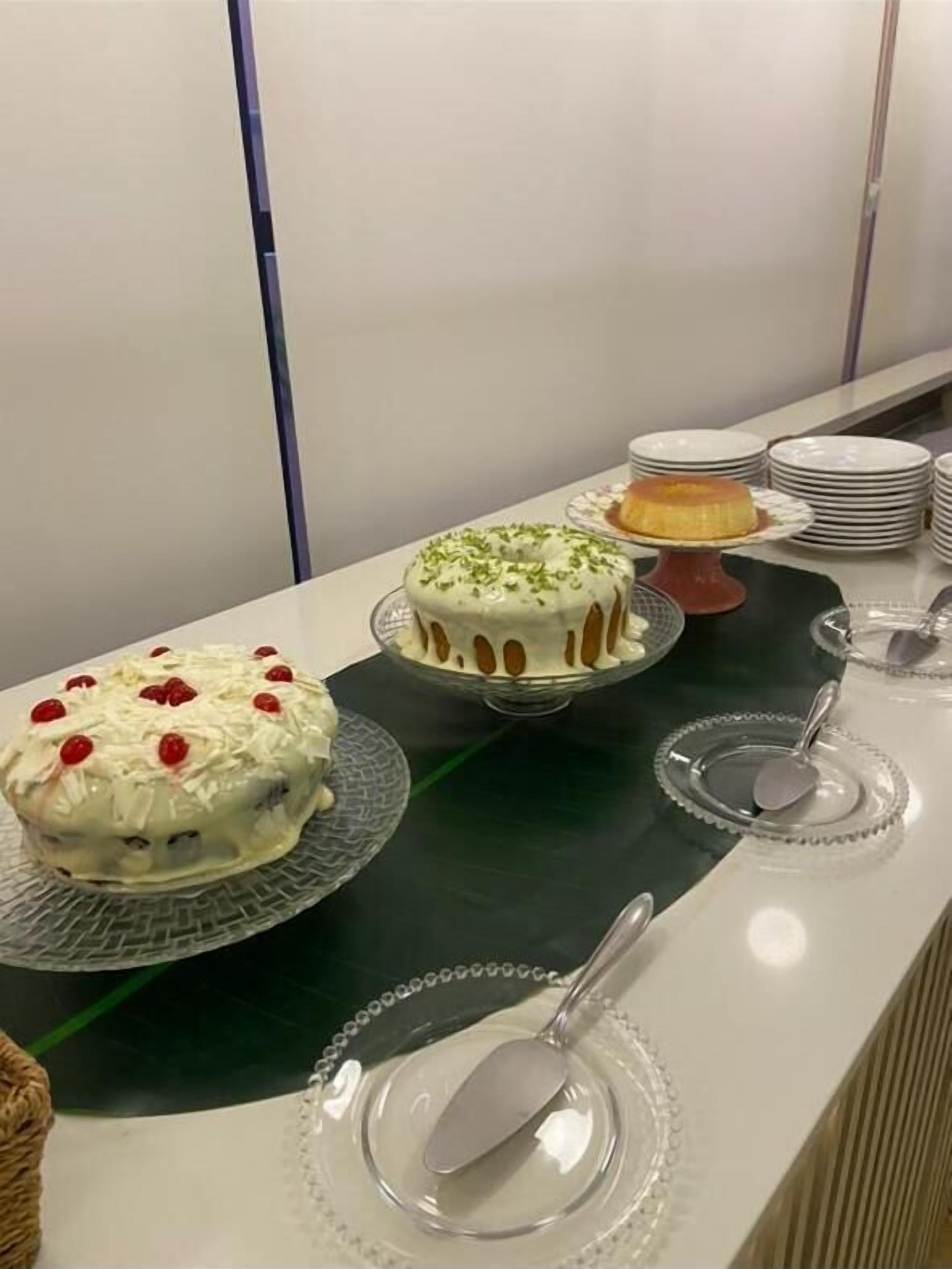Ein reichhaltiges Buffet mit verschiedenen Kuchen und einer Stapel Teller.