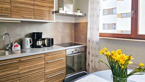 A modern kitchen with wooden cabinets, a built-in oven, a coffee maker, and a toaster. - 2-room WO07 - Platan (WO07) (Swinoujscie)