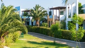 A residential area with modern houses, a well-maintained lawn, and palm trees. - Trilocale - Two Bedroom Apartment, Sleeps 6 (Castellaneta)