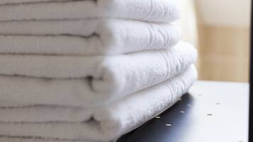 A stack of white towels on a dark surface.