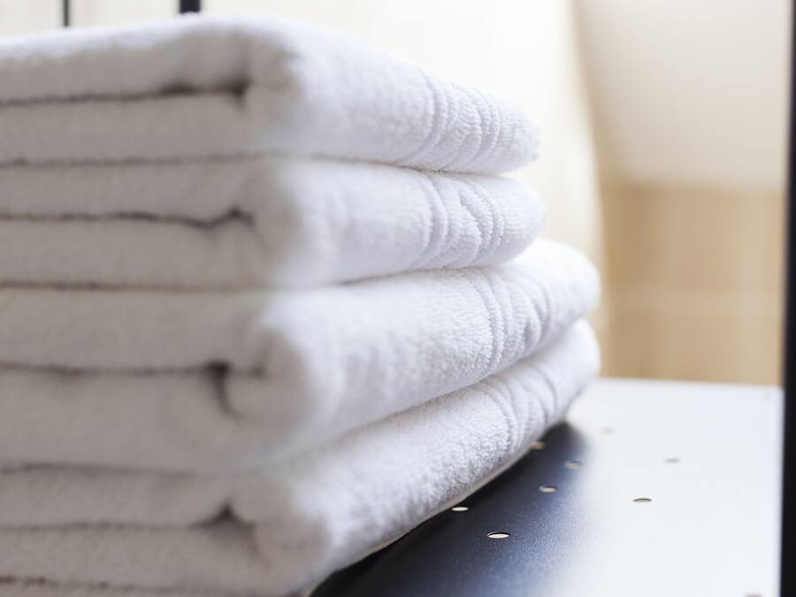 A stack of white towels on a dark surface.