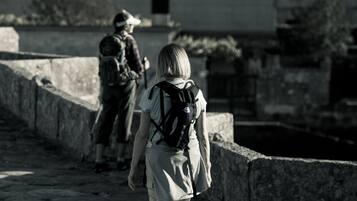 Una persona con una mochila caminando por un sendero de piedra.