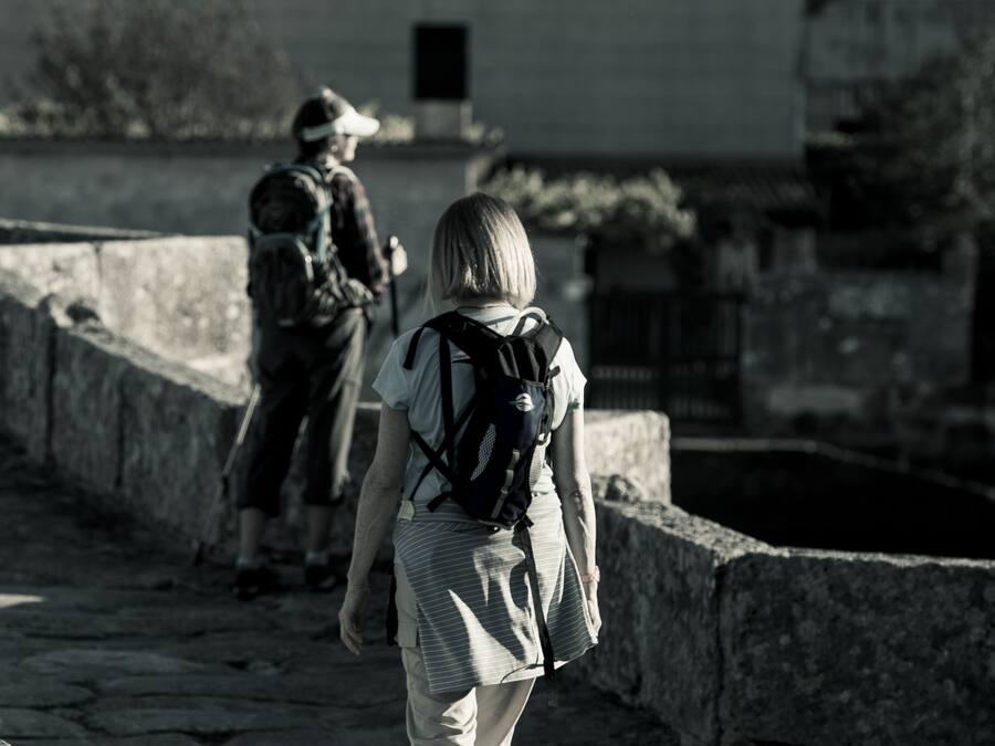 Una persona con una mochila caminando por un sendero de piedra.
