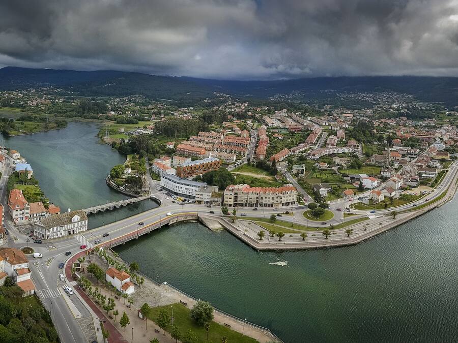 Eine Vogelperspektive einer Küstenstadt mit einem Fluss, Brücken und Wohnhäusern.