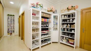 A well-organized storage room with shelves containing various items like jars, boxes, and decorative objects.
