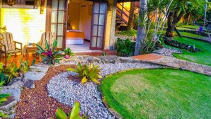 A well-maintained garden with a variety of plants, a stone pathway, and a grassy lawn. - Pousada Oasis (Tibau do Sul)