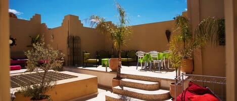 A courtyard with outdoor seating, steps, and potted plants.