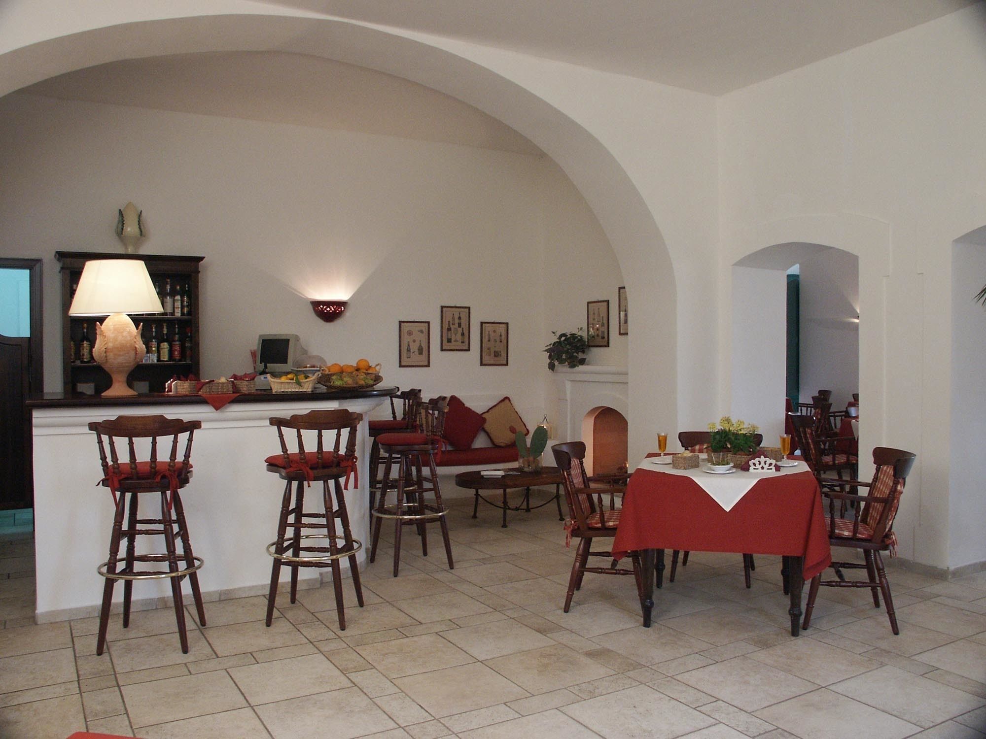 Ein Essbereich mit hoher, gewölbter Decke, eine Bar mit Hockern und ein Tisch für zwei Personen.