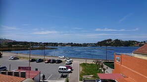A parking lot with cars and a building labeled "FROIZ". - Hotel Avenida (Baiona)