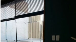 A room with a large window, a white dresser, and a green wall. - Copa Loft (Rio de Janeiro)