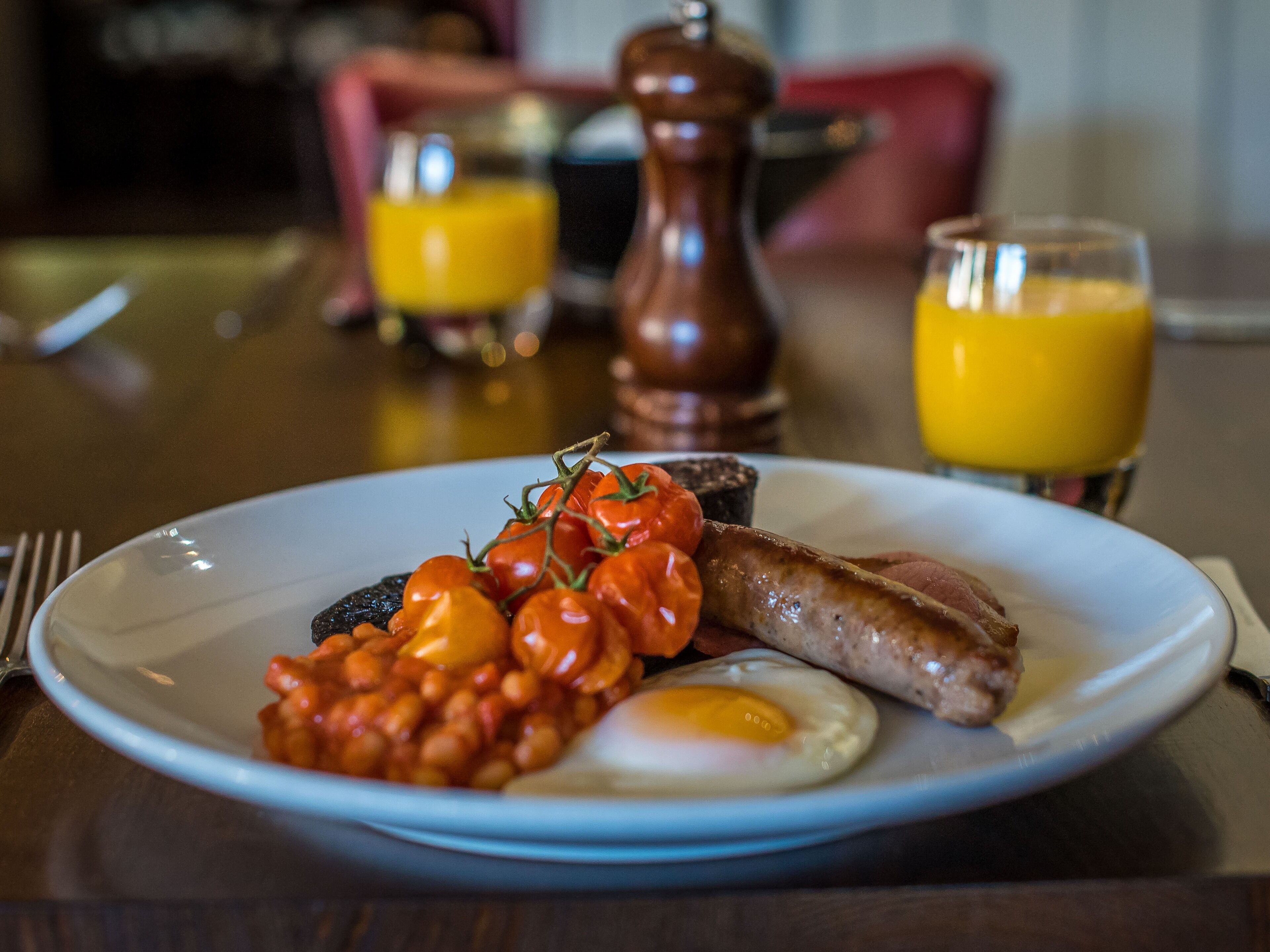 Un plato de desayuno con huevos, salchichas y tomates.