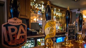 A bar with multiple beer taps, including IPA, batemans Gold, and Isle of Ely. - The Royal Standard (Ely)