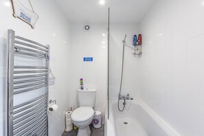 A modern bathroom with a toilet, bidet, and bathtub.