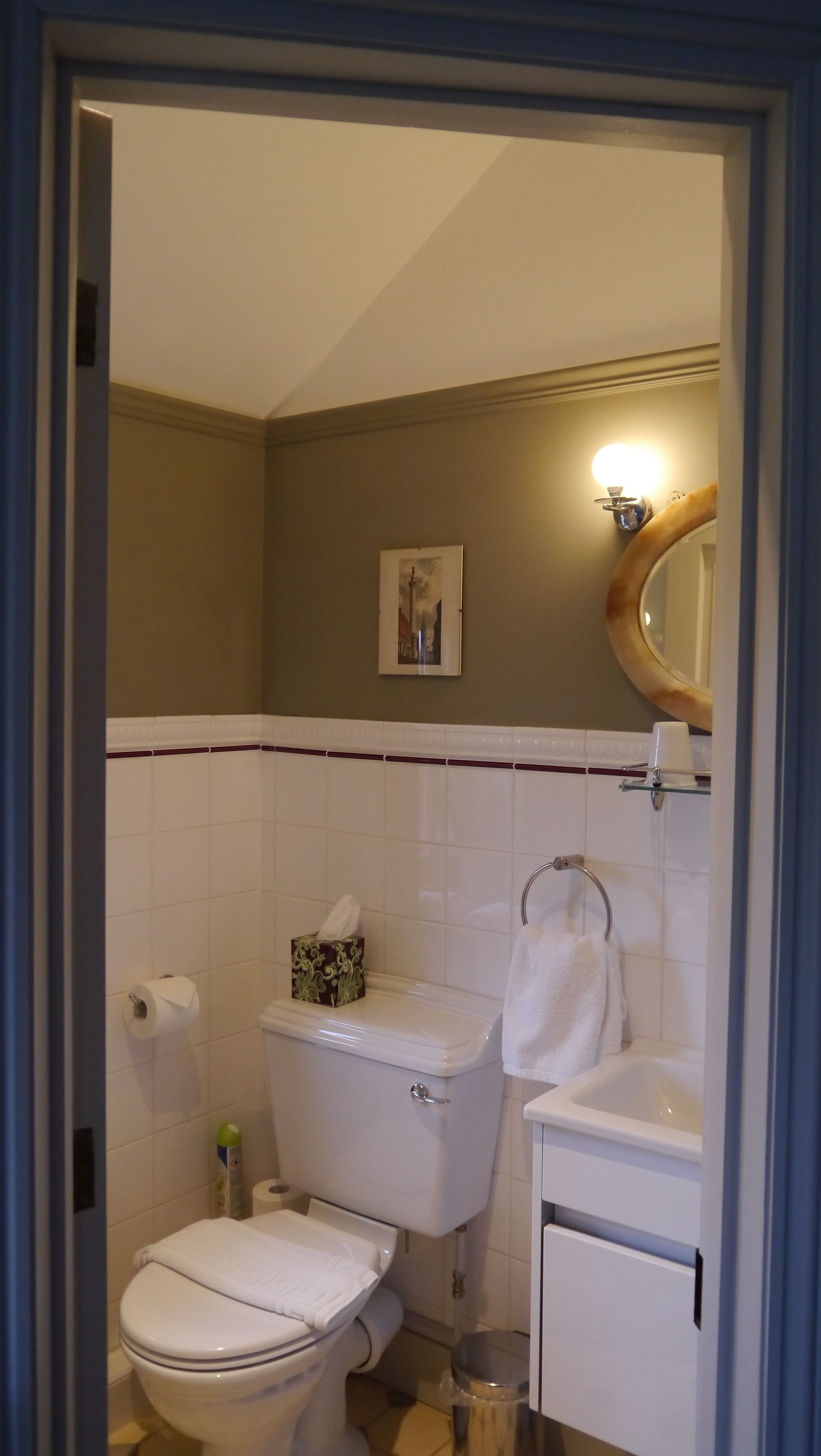 Une salle de bain avec des toilettes, un lavabo et un miroir.