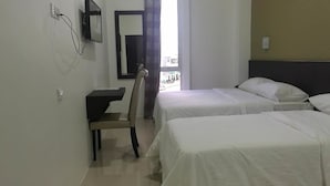 Camera d'albergo con due letti, una scrivania e una sedia.