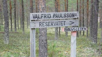 Un cartello in legno con indicazioni per la riserva naturale Valfrid Paulsson e il sentiero Isalsleden.