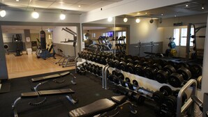 A gym with treadmills, weight benches, and a rack of dumbbells. - Hotell Vindelngallerian (Vindeln)