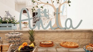 Een buffet met diverse gebakjes en desserts, een decoratieve boom, en een bord met de tekst 'Atilla'.