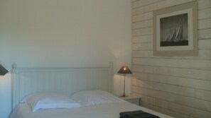 Una camera da letto con un letto, un comodino con una lampada e un quadro appeso al muro.
