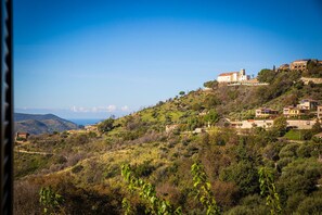 A hillside village with traditional architecture, a prominent church, and a view of the sea. - La Residenza Torchiara (Torchiara)