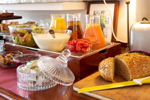 A breakfast buffet with various food items, including fruits, yogurt, and bread. - Amsterdam House Hotel (Amsterdam)