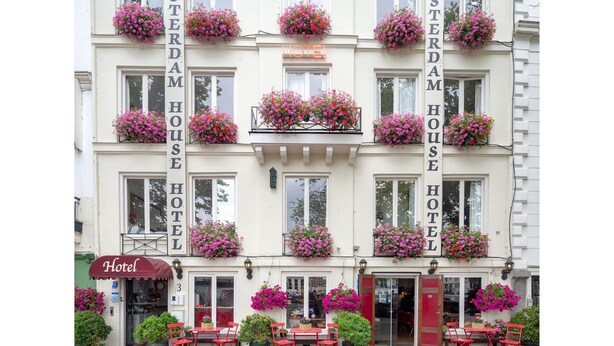 A hotel with multiple balconies adorned with flower boxes, a prominent 'Hotel' sign, and outdoor seating. - Amsterdam House Hotel (Amsterdam)