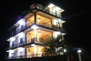 A multi-story hotel with balconies and a well-lit facade.